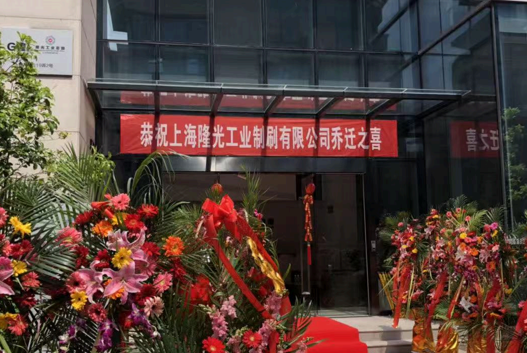 New headquarters entrance decorated with flowers and a red relocation banner