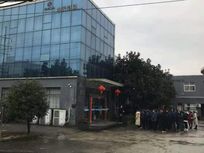 Longguang factory building with staff gathered at the entrance